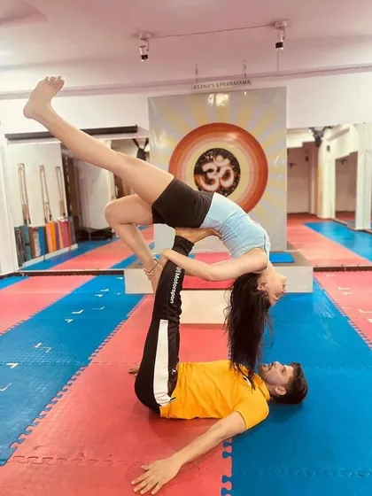 A beautiful expression of the "Reverse Bird" pose in acro yoga. The flyer opens their chest towards the sky, creating a wonderful heart-opening stretch supported by the base.