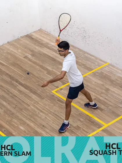 A player demonstrating perfect form and court positioning during a competitive match at the HCL Squash Tour in Kolkata.