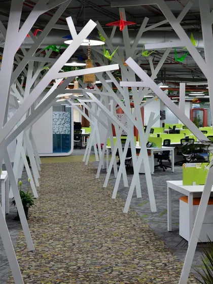 We created a "walk in the woods" in this IT office using abstract tree-like structures and a pebble-filled pathway. This installation serves as a creative walkway that divides the workspace.