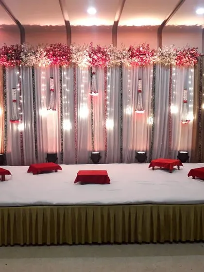 I also create traditional setups for events like a sangeet or mehendi. This stage features low, comfortable floor seating with bolsters, set against a backdrop of drapes and warm hanging lights.