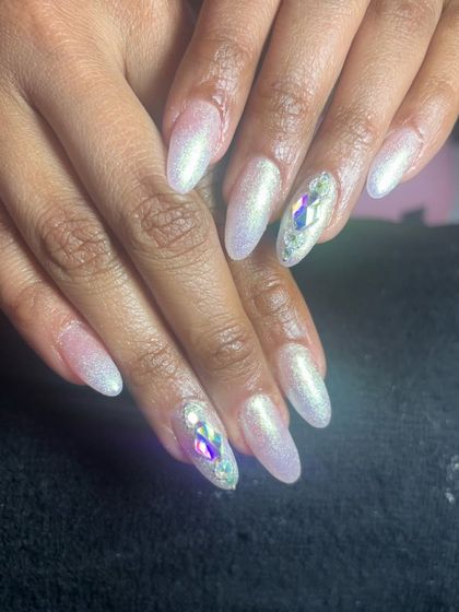 A pearly white set with a shimmery finish and large, multi-faceted crystals on the accent nails.