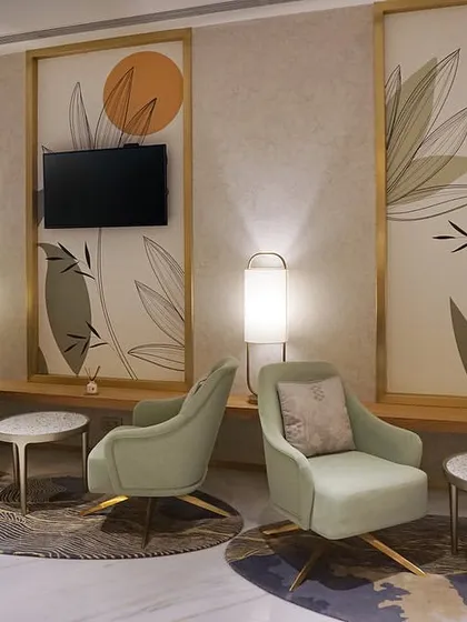 The main lounge area at the VVIP Lounges in Bangalore International Airport's Terminal 2. We designed this space to feel verdant and serene despite having no natural light, using a soft green color palette, custom lighting, and botanical-themed wall panels to create an oasis for travelers.