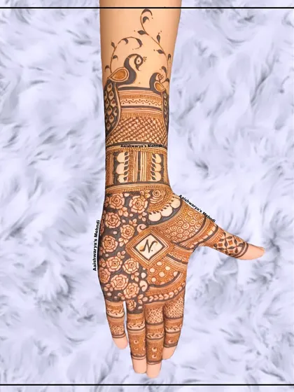 A beautiful full-hand design with peacocks on the arm and a dense floral pattern on the palm, personalized with an initial.