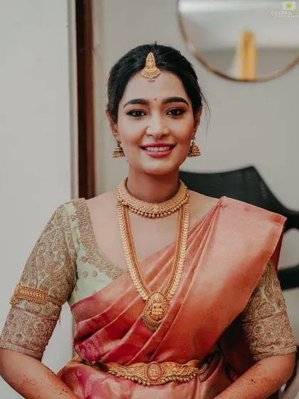 Another portrait of the bride in her peach saree, showcasing the beautiful drape and the subtle elegance of her custom-designed blouse.