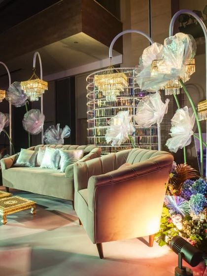 A comfortable and stylish lounge area set up near the stage. We used plush velvet sofas, elegant chandeliers, and oversized floral sculptures to create a chic space for guests to relax.