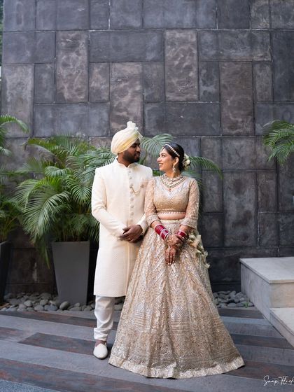 A gorgeous shot of Ria and her husband. Her makeup complements her partner's attire perfectly, creating a cohesive and elegant look for their wedding photos.