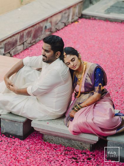 A moment of peaceful rest on a bed of flowers. This image combines traditional attire with a touch of modern romance, creating a serene and beautiful couple portrait.