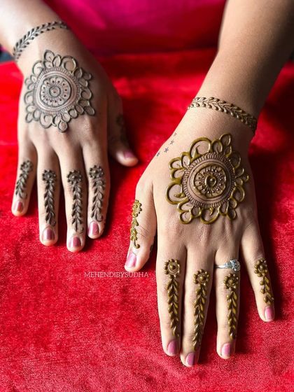 A beautiful and simple minimalist design. It features a mandala on the back of the hand with delicate leafy vines for finger details, connected by a simple band.