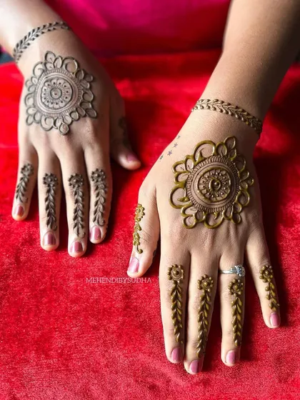 A beautiful and simple minimalist design. It features a mandala on the back of the hand with delicate leafy vines for finger details, connected by a simple band.