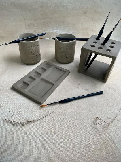 More beautiful greenware from our hand-building course. This image shows a custom paint palette, brush holders, and a water cup, all ready for their first firing.