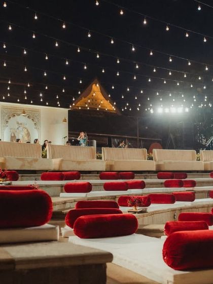 The amphitheater seating at dusk, with strings of lights creating a canopy of stars overhead. This unique seating arrangement ensures every guest has an intimate and cinematic view of the proceedings.