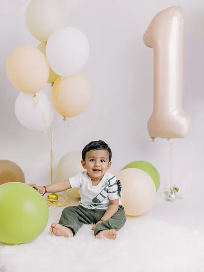A smiling birthday boy surrounded by balloons. The classic "one" balloon makes this a perfect first birthday portrait.