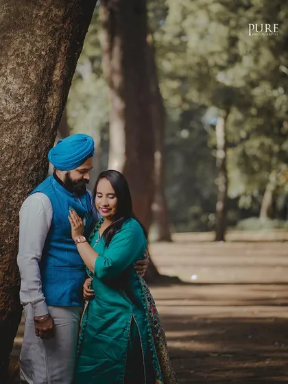 An intimate moment shared under the trees. The soft, natural light filtering through the leaves creates a beautiful, gentle mood for this portrait of Karan and Simarpreet.