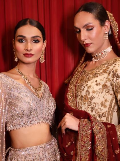 Two models showcasing the beautiful work of our students backstage. They learn to create cohesive looks that align with the designer's vision.