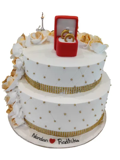 I designed this two-tier engagement cake with a quilted pattern, shimmering gold ribbon, and a beautiful edible ring box on top. It's a sweet and stylish way to announce your commitment.