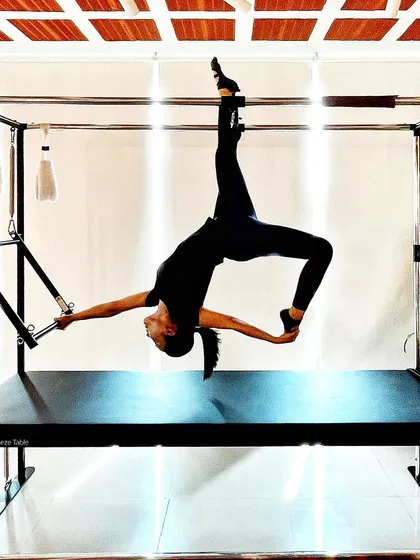 Discover how Pilates enhances your mental well being. This graceful pose on the Cadillac is as much about focus and mental clarity as it is about physical strength.