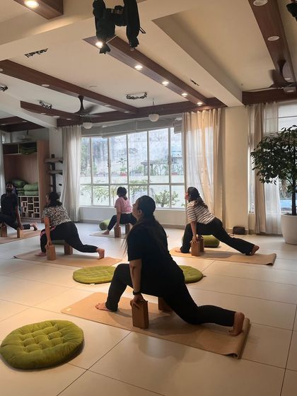 A class using yoga blocks to support a low lunge, allowing for a deeper hip-opening stretch while maintaining proper alignment.