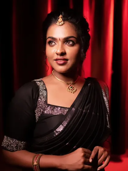 A bold and beautiful look with a black saree. The makeup is striking, with defined eyes and a confident pose.