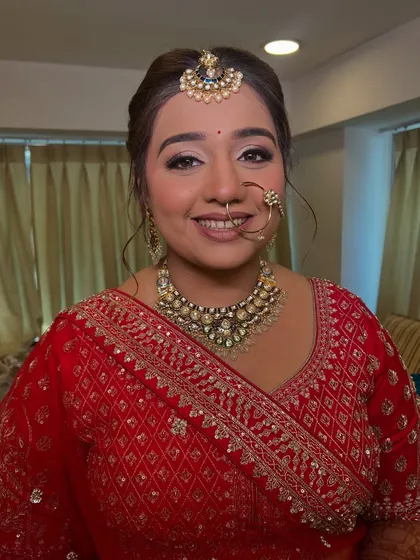 A close up of the bride's happy expression. The clean lines of the updo draw attention to her features and the intricate details of her wedding jewelry.