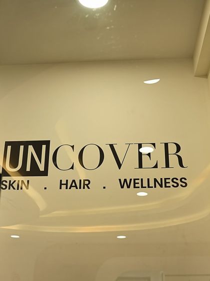 The Uncover logo on the glass door of our clinic, a symbol of our commitment to skin, hair, and wellness.