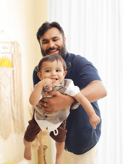A proud father holds his son during a pre birthday family photoshoot. We love capturing the special bond between fathers and their children in our sessions.