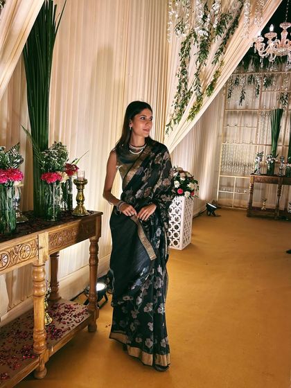 A classic black floral sari worn at a wedding reception. This is a versatile piece that can be dressed up or down for any festive event.