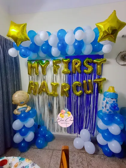 A 'My First Haircut' celebration setup with a blue and white balloon arch and foil letters.