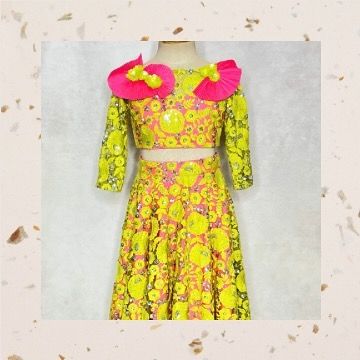For the girl who loves to stand out, this fluorescent lehenga is pure fun. It features neon yellow embroidered net over a bright pink base, with quirky pleated flowers on the shoulders.