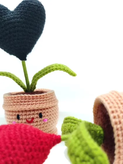 A playful shot showing a "fallen" red heart pot next to the standing black one, adding a bit of story to the product.