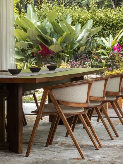 We sourced a large live-edge dining table to anchor this space and reupholstered the client's existing chairs to blend old and new. The setup is perfect for their love of entertaining.