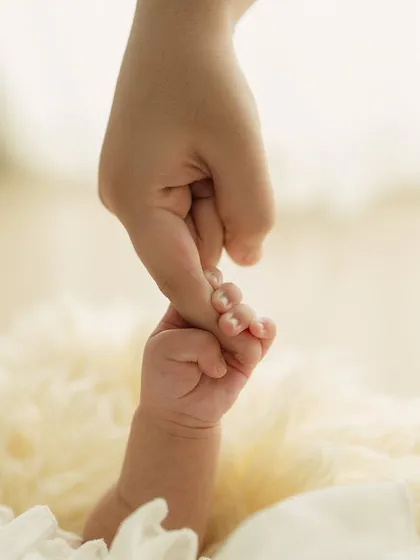 A newborn's hand wrapped tightly around a parent's finger. This simple, powerful image symbolizes trust, connection, and the start of a new journey.