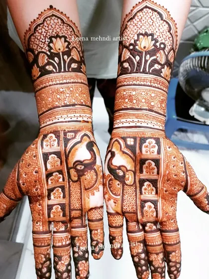 A beautiful bridal design featuring elephants within a jharokha grid. The upper arms are adorned with lotus motifs, creating a cohesive and traditional piece of art.