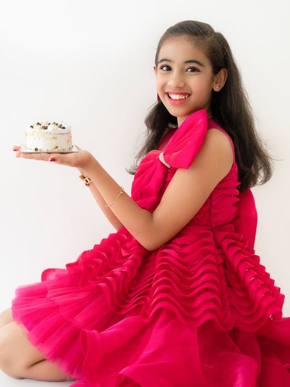 A bright, happy close-up of the birthday girl, showcasing her beautiful smile and gorgeous pink party dress.