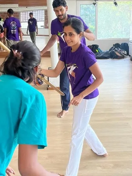 An instructor helps a student learn how to play the Berimbau. We offer hands-on guidance to help you master the instruments.