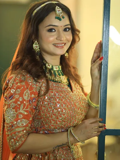 Another angle of the model in the orange lehenga, showing the versatility of my makeup skills.