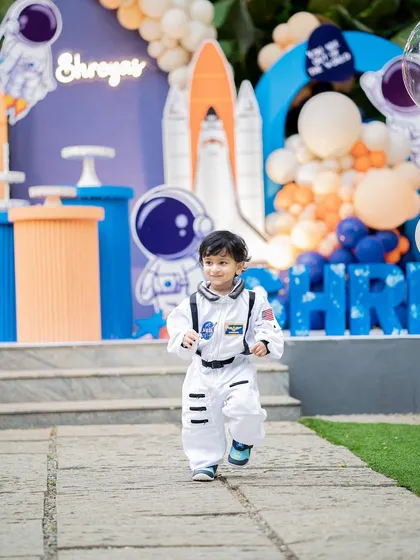 It's not just about the decor, it's about the memories. I love seeing the birthday child fully immersed in the theme, like this little astronaut ready for an adventure at his space-themed party.