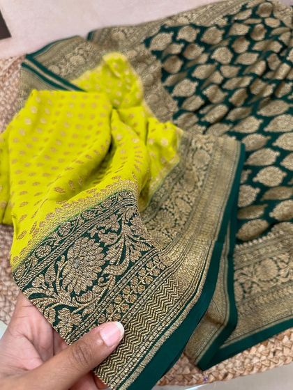 A vibrant lime green and bottle green pure Banarasi Kadi georgette saree. The intricate floral border and paisley motifs add to its traditional charm.