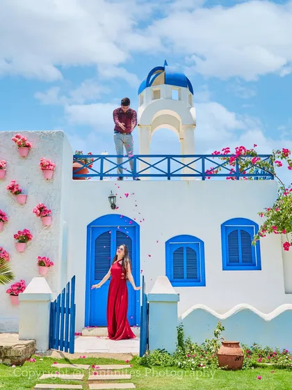 A playful moment captured at our Santorini-inspired set, complete with flower-adorned walls, creating a cheerful and romantic atmosphere.