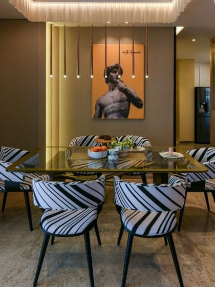 In the Clifton House project, the dining area carries the home's bold color story with a unique twist. The showstopper table features a veneer base with intersecting gold metal bars, paired with patterned chairs for a touch of personality.