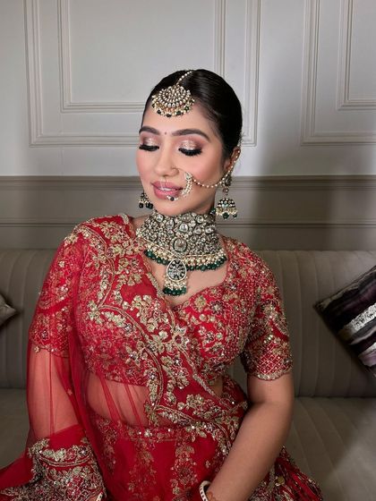 A close-up of the bride's serene expression, highlighting the intricate details of the polki choker and matching maang tikka.