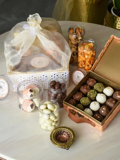 This is what a celebration looks like in a box. My custom Diwali hampers are designed to be a complete experience, featuring an assortment of my signature chocolate truffles, jars of savory and sweet nuts, and a traditional diya to light up the festivities.