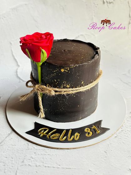 Simplicity and elegance. A rich, dark chocolate cake with a rustic twine wrap and a single, beautiful red rose.