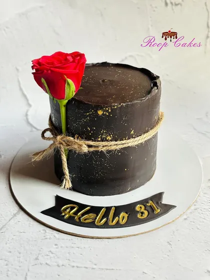 Simplicity and elegance. A rich, dark chocolate cake with a rustic twine wrap and a single, beautiful red rose.
