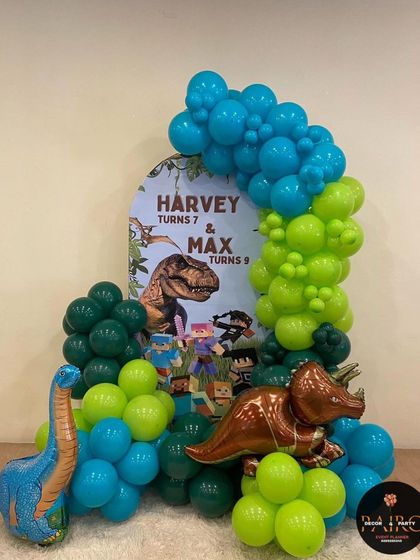 A fun dinosaur and Minecraft combo theme for a shared birthday party, with a custom backdrop and jungle-colored balloons.