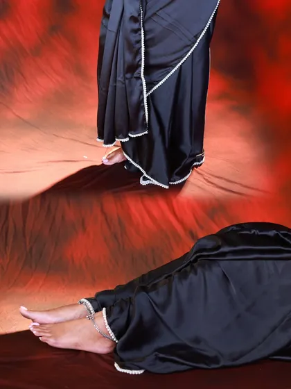 An abstract, artistic shot combining two different poses. It focuses on the details of the black saree, the pearl border, and the model's feet.