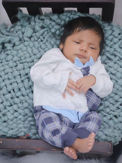 Another angle of our little model, showing the full setup with a cozy blanket and cloud-like fluff. Our newborn photography is all about creating a dreamy scene.