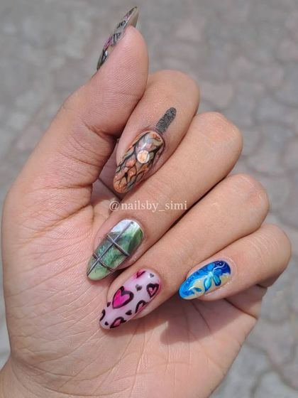 A collection of some of my favorite hand-painted nail art, inspired by different aesthetics. This hand shows a mix of hearts, a window scene, and a beautiful blue floral design.