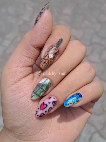 A full hand of mismatched, artistic nails, each with a unique, hand-painted design inspired by different aesthetics.