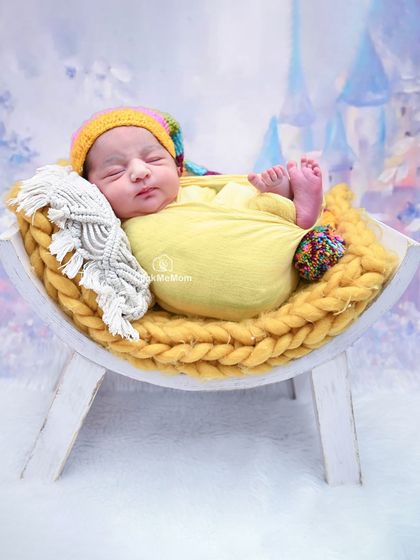 With a whimsical castle backdrop, this portrait adds a touch of fairytale magic to the classic swaddled pose on a yellow blanket.