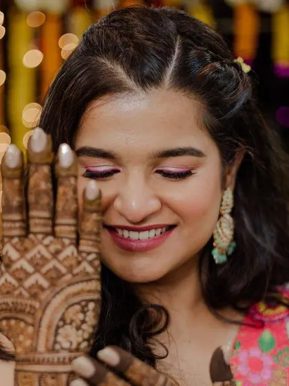 Showing off the beautiful Mehendi design. The makeup is kept soft and glowing to complement the festive atmosphere.
